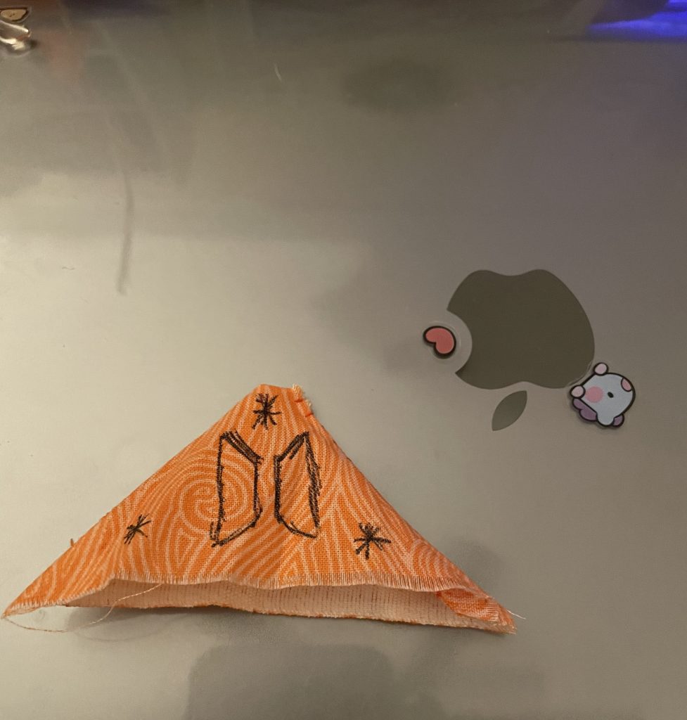 My second attempt at a BTS-themed bookmark pattern with black pen on orange fabric.